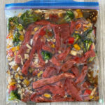 clear bag with beef strips, vegetables, and sauce