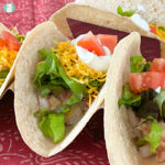 flour tortillas filled with fish, lettuce, diced tomatoes, shredded cheese