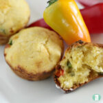 muffins of cornbread next to a mini yellow and red pepper