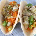 flour tortillas with fish, shredded carrots, and lettuce