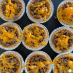 mini tart shells filled with ground beef and topped with cheddar cheese
