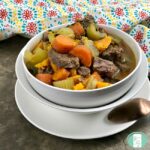bowl of beef chunks, carrots, celery in a broth