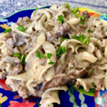 egg noodles topped with ground beef in a cream sauce and fresh parsley