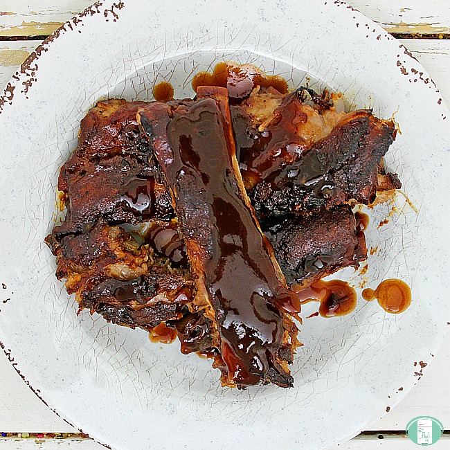 ribs with a sticky red sauce on a white plate
