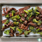 beef strips and broccoli on a sheet pan