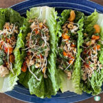 lettuce leaves filled with ground chicken, cashews, diced vegetables, and crunchy noodles