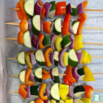 skewers of zucchini, yellow and red peppers, and purple onions