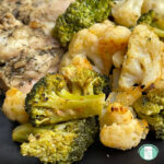 broccoli and cauliflower on a plate with chicken visible