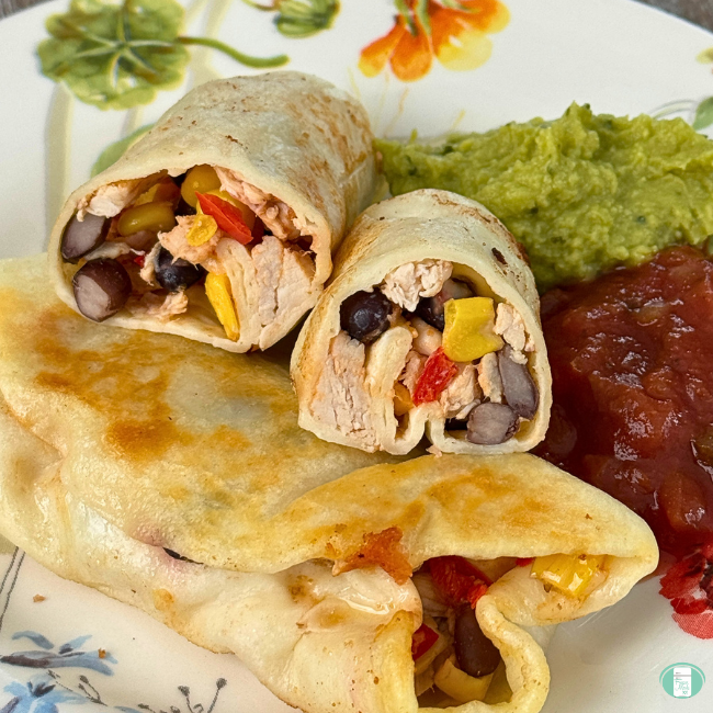 Chicken burritos served with sides of guacamole and salsa